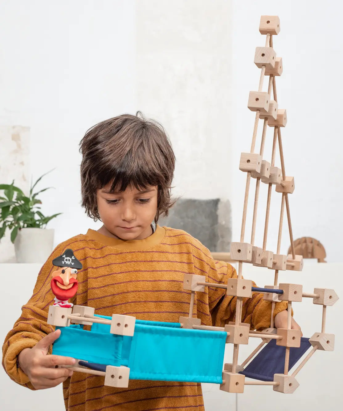 Child holding a pirate ship build made from piece out of the Trigonos mini medium construction kit 