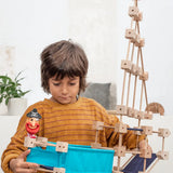 Child holding a pirate ship build made from piece out of the Trigonos mini medium construction kit 