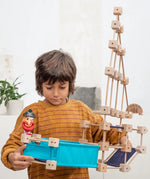 Child holding a pirate ship build made from piece out of the Trigonos mini medium construction kit 