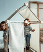 Children inside a tent made from the Trigonos kernel organic set showing white cotton sheets used on the sides and roof