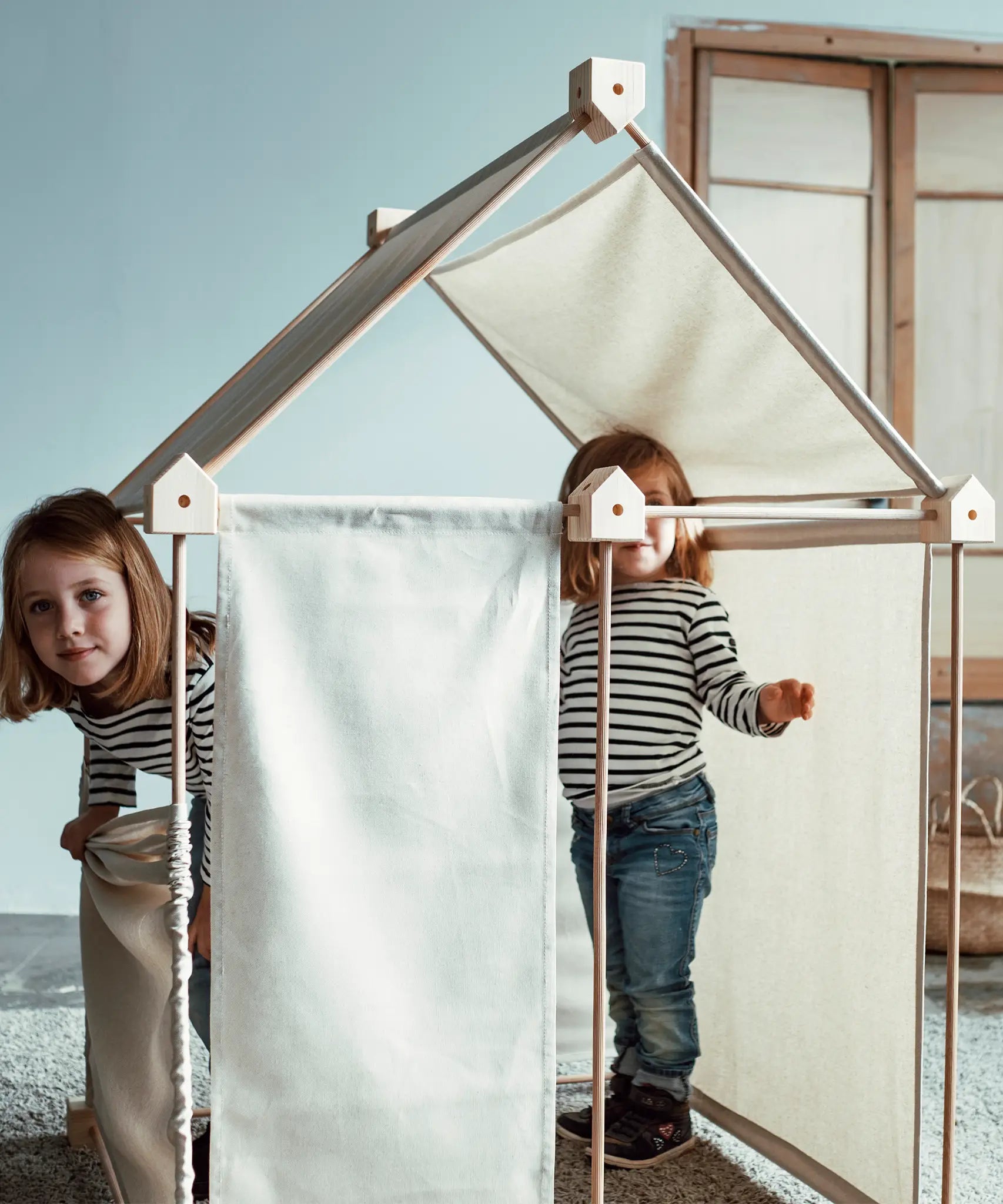 Children inside a tent made from the Trigonos kernel organic set showing white cotton sheets used on the sides and roof