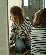 Child playing inside a tent structure made from the Trigonos wooden kernel organic construction set