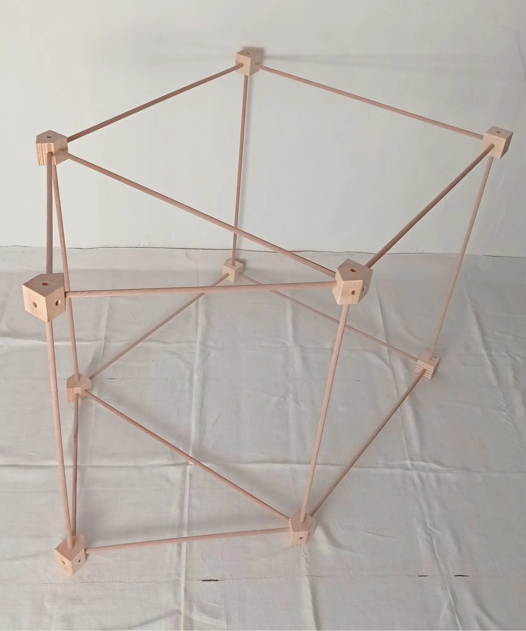Trigonos big start set showing a tent build on its side made up from wooden poles and corner blocks 