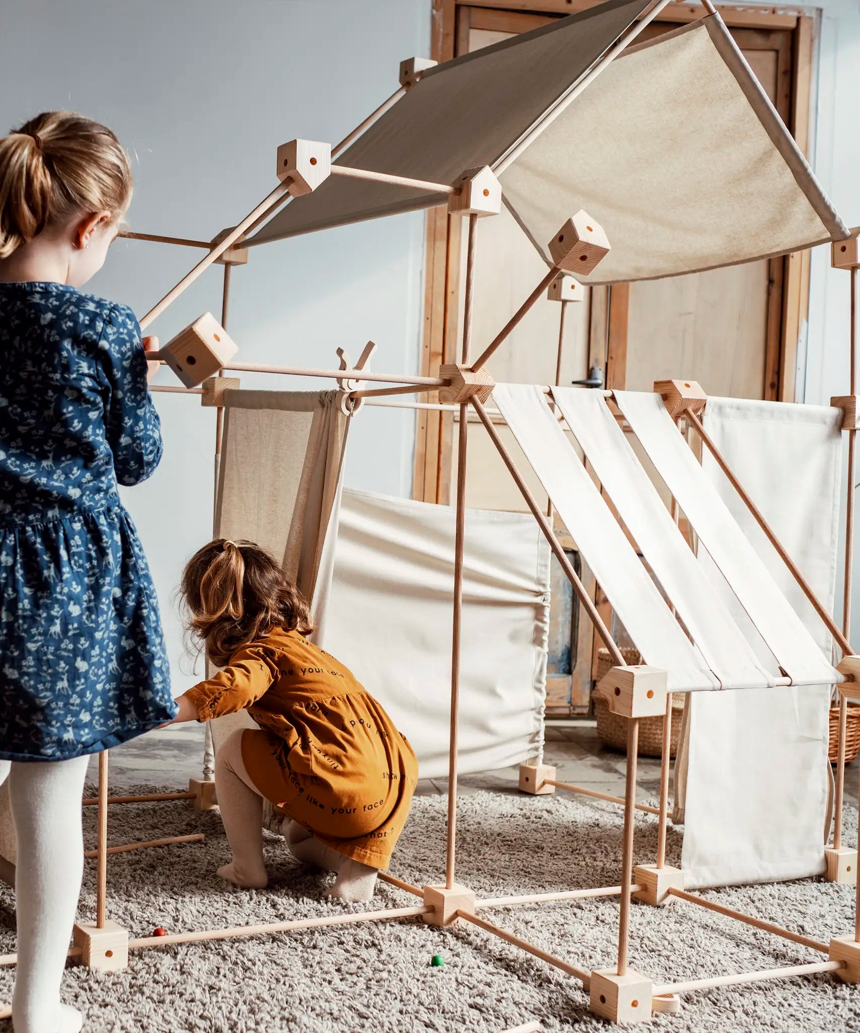 Children building multiple dens using the Trigonos family wooden construction set 