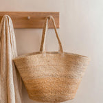 Turtle Bags natural block colour jute basket hanging on a wooden coat hanger