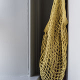 Turtle Bags organic long handle shopping bag hanging from a white wall