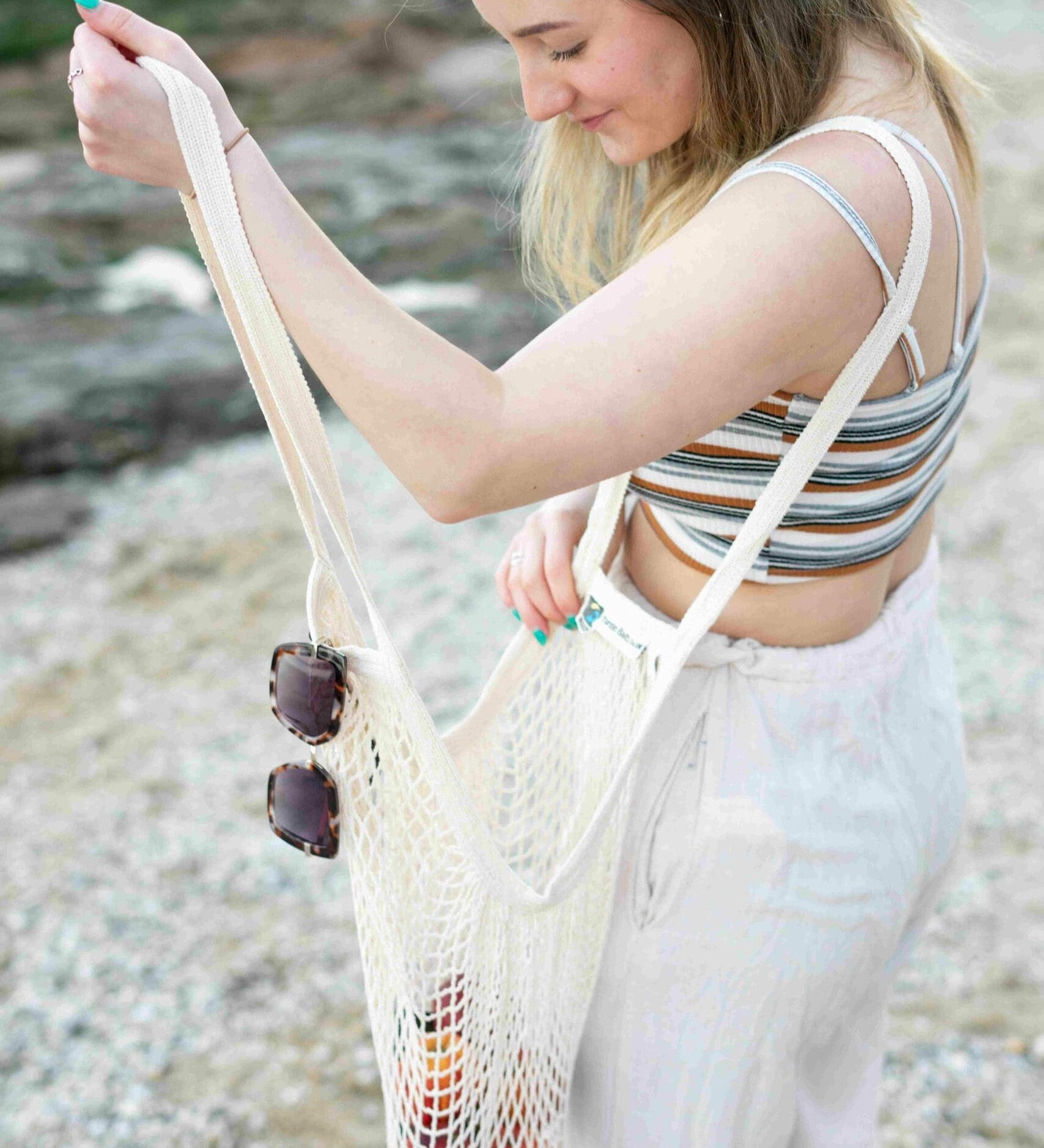 A woman carrying her groceries in the Turtle Bags long handle grocery shopping string bag