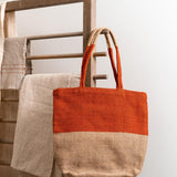 Turtle Bags eco-friendly orange block colour tote bag hanging on a wooden hook in front of a white wall