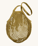 The Turtle Bags organic and fair trade cotton string bag for grocery shopping - in a vegetable dyed botanic ochre yellow colour