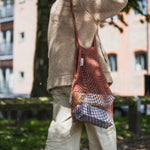 Woman walking with the Turtle Bags eco-friendly reusable botanic string bag over her shoulder