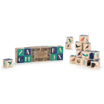 Uncle goose plastic free wooden bird toy blocks stacked in a pile on a white background next to their cardboard packaging