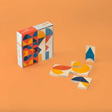 Uncle Goose kids plastic-free wooden mod chips laid out on an orange background next to their box