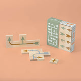 Uncle Goose plastic-free toy arrow chips laid out on an orange background next to their cardboard box
