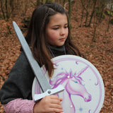 Child pictured with the Vah Arabella Unicorn Wooden Sword in one hand and the matching arabella shield in the other hand