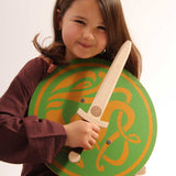 child smiling holding a Celtic sigar shield and a wooden wiki dagger