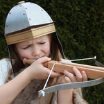 Child wearing the Vah Gallic Roman Helmet taking aim with a crossbow