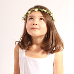 Child wearing the vah cream flower crown and a white dress