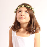 Child wearing the vah cream flower crown and a white dress