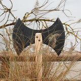 Vah Two-edged Wooden Viking Hatchet pictured outdoors placed against a fence behind reeds