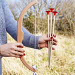 A close up of a child's hand folding the bow and arrows from the Vah Easy Aim Bow with Safety Arrows Set.