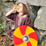 child wearing a viking costume. drinking from a drinking horn holding a Vah Grimwald Round Wooden Shield - Red & Yellow