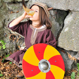 child wearing a viking costume. drinking from a drinking horn holding a Vah Grimwald Round Wooden Shield - Red & Yellow