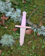 the dagger from the Vah Isolde Unicorn Mini Wooden Shield & Dagger Set pictured outdoors on grass