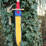 Vah Landsknecht Yellow & Blue Wooden Sword Set pictured on an ivy covered tree