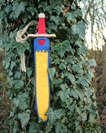 Vah Landsknecht Yellow & Blue Wooden Sword Set pictured on an ivy covered tree