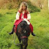 Child wearing the Vah Red Little Marian costume Dress with a cream coloured floral crown whilst riding a pony