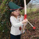 Child outdoors playing with the Vah Mini Wooden Bow with Safety Arrows