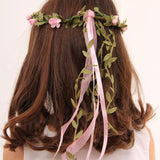 child with brown coloured hair wearing a Vah pink flower crown. View of the back of the child's head