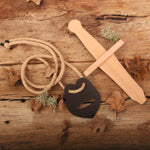 Vah Recycled Leather Sword Hanger pictured on a wooden surface next to small sword