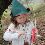 A child wearing a VAH robin hood hat playing with a bow and arrow.