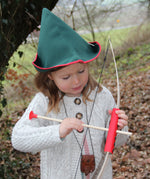 A child wearing a VAH robin hood hat playing with a bow and arrow.