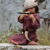 A child in full Viking costume including the Vah Viking Tunic, helmet and drinking horn. The child is playing with a cross bow.