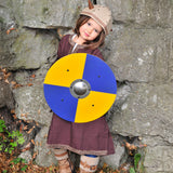 A child wearing the Vah Viking Tunic costume with a Viking helmet holding up a round toy shield.
