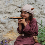 Child smiling playing with the Vah Junior Wooden Bow toy