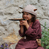 Child smiling playing with the Vah Junior Wooden Bow toy
