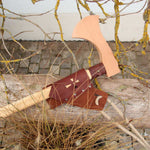 vah wooden battle axe placed on a wooden bench outdoors