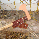 vah wooden battle axe placed on a wooden bench outdoors