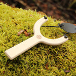 vah wooden sling shot placed on moss outdoors