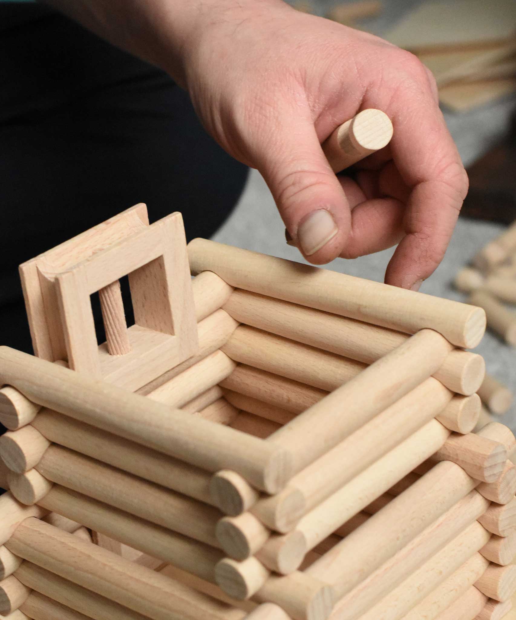 A close up of a tower being built using pieces from the Walachia Vario XL Building Set 184 Pieces. This modular wooden building block system is perfect for those who enjoy a challenge. The sets are available in various sizes at Babipur.  