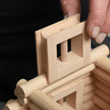 A close up of a wooden window piece being placed in a tower structure built using pieces from the Walachia Vario XL Building Set 184 Pieces.  This modular wooden building block system is perfect for those who enjoy a challenge. The sets are available in various sizes at Babipur.  
