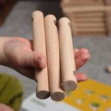 Three pieces of Walachia Vario in a child's hand. This modular wooden building block system is perfect for those who enjoy a challenge. The sets are available in various sizes at Babipur.  