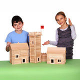 Children standing by build created using the wooden pieces from the Walachia Vario Massive Box Wooden Building Set 418 Pieces.