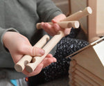 A close up of some long wooden blocks from the Walachia Vario Building Sets in a child's hands. This modular wooden building block system is perfect for those who enjoy a challenge. The sets are available in various sizes at Babipur.  