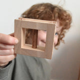 A child holding up a wooden window from the Walachia Vario Building Sets up to the camera. This modular wooden building block system is perfect for those who enjoy a challenge. The sets are available in various sizes at Babipur.  