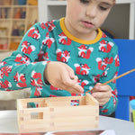 A child patiently and carefully building the WALACHIA house kit