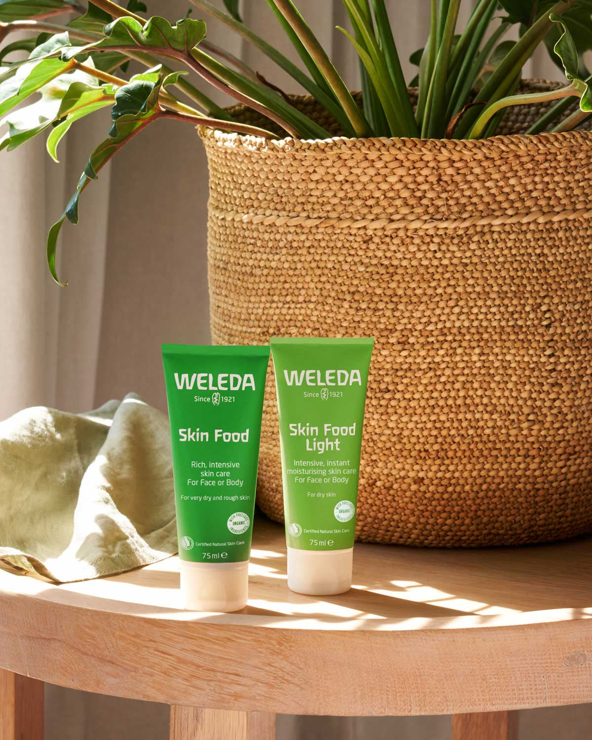 A tube of Weleda Skin Food pictured next to the Skin Food Light